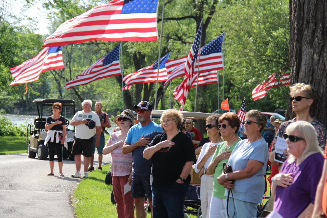 Attendees honor the flag as the national anthem is performed during a Memorial Day ceremony on Monday, May 30, 2022, at Oakdale Cemetery in Adel.