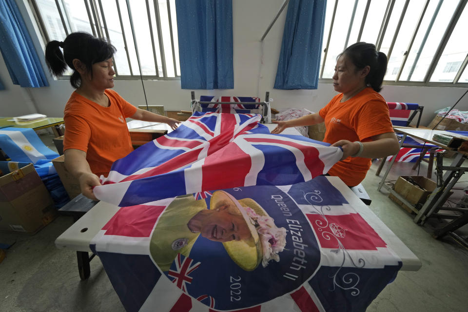 Workers produce British flags at the Shaoxing Chuangdong Tour Articles Co. factory in Shaoxing, in eastern China's Zhejiang province, Friday, Sept. 16, 2022. Ninety minutes after Queen Elizabeth II died, orders for thousands of British flags started to flood into the factory south of Shanghai. (AP Photo/Ng Han Guan)