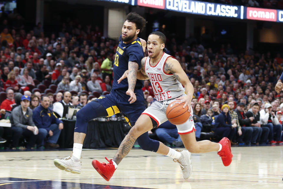 Ohio State's CJ Walker (13) drives on West Virginia's Jermaine Haley (10) during the first half of an NCAA college basketball game Sunday, Dec. 29, 2019, in Cleveland. West Virginia defeated Ohio State 67-59. (AP Photo/Ron Schwane)
