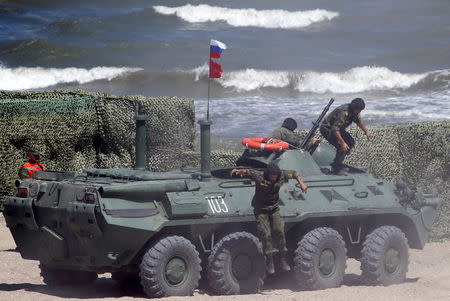 Russian navy servicemen leave an armoured personnel carrier (APC) as they take part in the Caspian Derby-2015 international naval contest during the International Army Games-2015 in the Dagestan's port city of Kaspiysk, Russia, August 5, 2015. REUTERS/Sergei Karpukhin