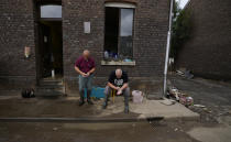 Resident Patrick Martin, right, and a friend in front of their flood damaged home in the La Brouck neighborhood of Trooz, Belgium, Tuesday, July 27, 2021. Patrick Martin and his companion Cindy Lacroix still find it hard to sleep after they feared for their lives during deadly floods nearly two weeks ago, isolated and trapped in the top floor of their house for two days before they were rescued on a small boat by firefighters. (AP Photo/Virginia Mayo)