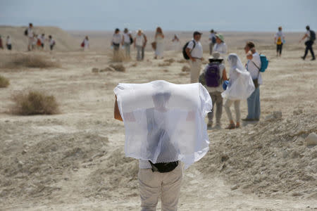 A woman holds up a white fabric as she takes part in a march attended by Palestinian and Israeli women, as part of an event organised by "Women Wage Peace" group, calling for an end to the Israeli-Palestinian conflict, near the Jordan River, in the occupied West Bank October 8, 2017. REUTERS/Ronen Zvulun