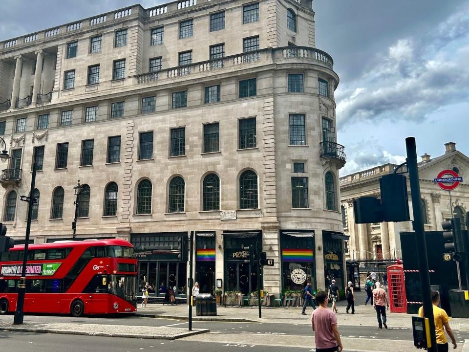 double decker bus riding down street in soho in london during the summer