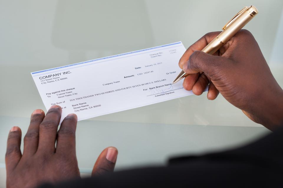 Close-up of a person filling a blank check
