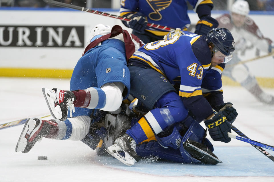 Colorado Avalanche's Nazem Kadri, left, falls on St. Louis Blues goaltender Jordan Binnington behind teammate Calle Rosen (43) during the first period in Game 3 of an NHL hockey Stanley Cup second-round playoff series Saturday, May 21, 2022, in St. Louis. Binnington was injured on the play and left the game. (AP Photo/Jeff Roberson)