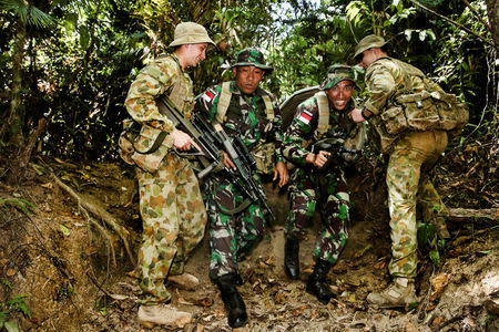 Australian Army soldiers assist Indonesian Army personnel during the Junior Officer Combat Instructor Training course conducted by the Australian Army's Combat Training Centre in Tully, Australia, October 10, 2014. Australian Defence Force/Handout via REUTERS