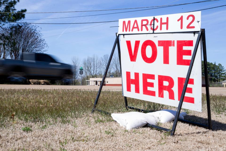 A truck passes a sign promoting voting at the polling location at Cornerstone Church in Southaven, Miss., on Tuesday, March 12, 2024.