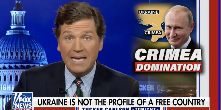 Screenshot of Tucker Carlson with a photo of Vladimir Putin to the right.