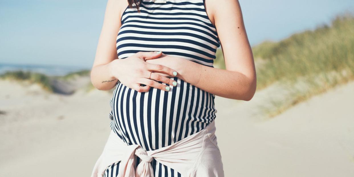 pregnant woman in striped maternity dress at beach