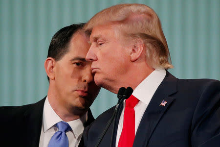 FILE PHOTO: Republican 2016 U.S. presidential candidate Wisconsin Governor Scott Walker (L) whispers to businessman and fellow candidate Donald Trump in the midst of a commercial break at the first official Republican presidential candidates debate of the 2016 U.S. presidential campaign in Cleveland, Ohio, U.S., August 6, 2015. REUTERS/Brian Snyder/File Photo