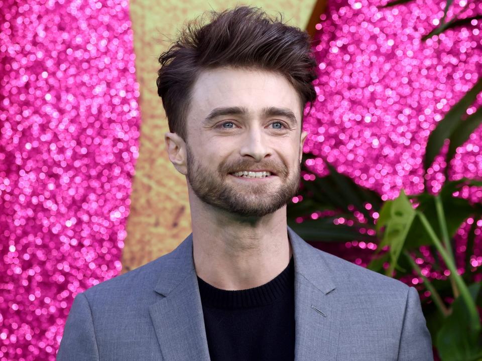 daniel radcliffe posing for a photo on the red carpet at the premiere of the lost city