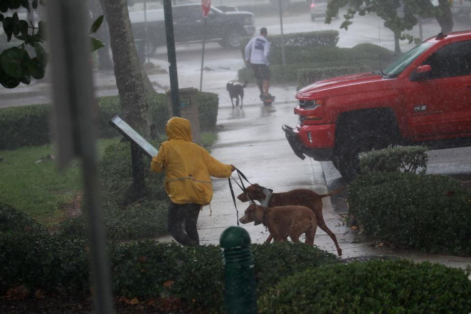 Storm spectators run for cover at Jetty Park on Wednesday, Sept. 28, 2022, in Fort Pierce, Fla., as wind and rain bands from Hurricane Ian begin to pound the Treasure Coast.