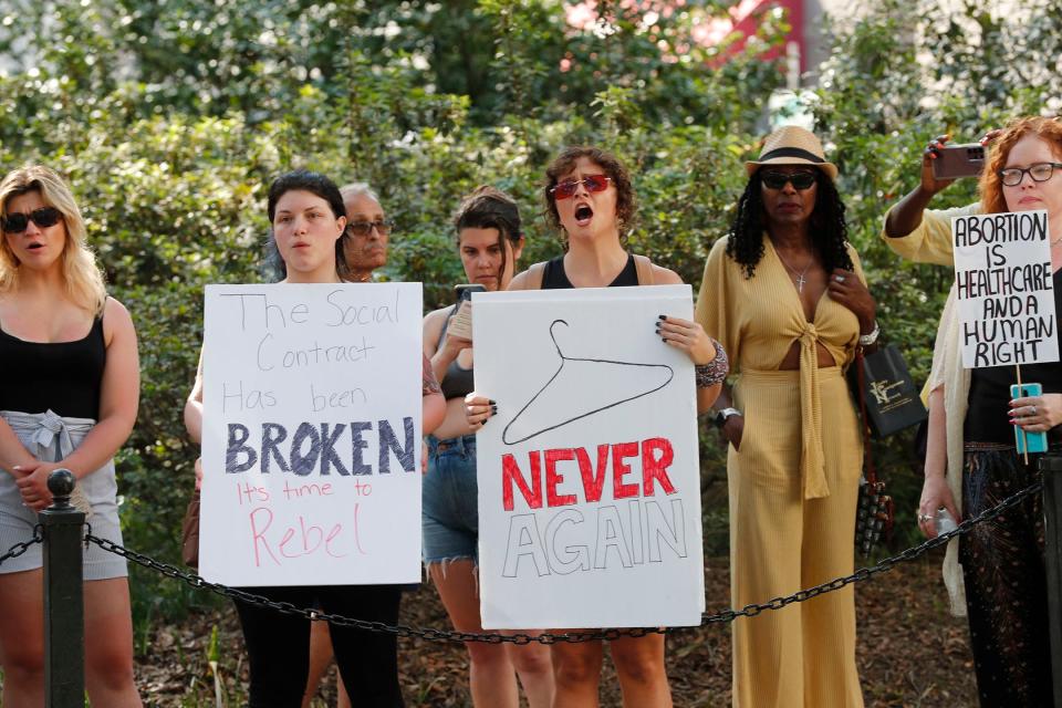 Participants hold signs during an abortion rights rally in Savannah.