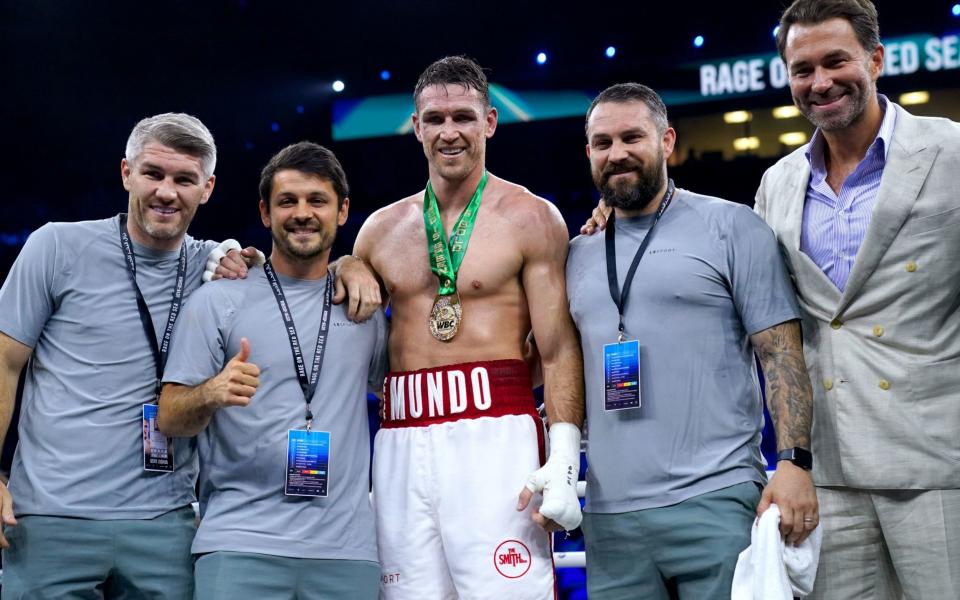 Callum Smith (centre) celebrates with boxing promoter Eddie Hearn (right) and his team after winning - PA