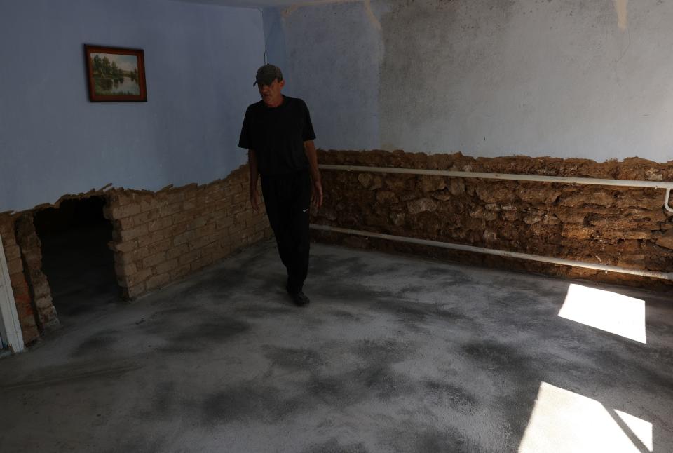 A local resident of Snihurivka, Mykolaiv region repair his damaged house due to flood following damage sustained to the Kakhovka hydroelectric power plant dam (AFP via Getty Images)