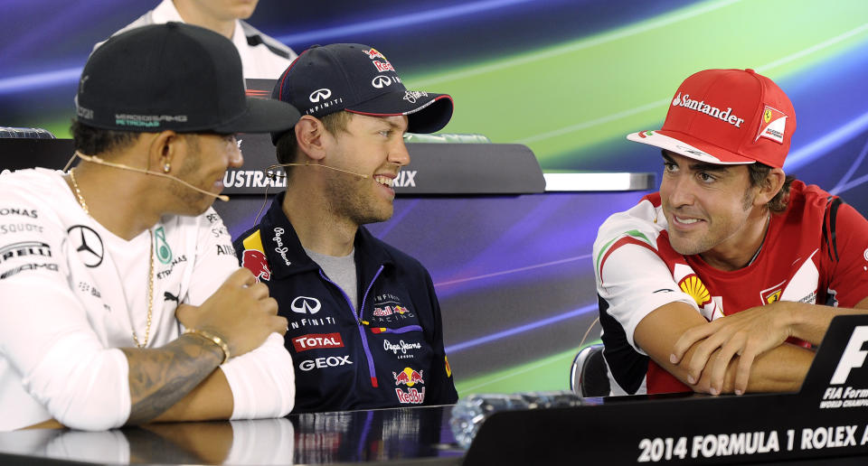 Red Bull driver Sebastian Vettel of Germany center, laughs with Mercedes driver Lewis Hamilton of Britain left, and Ferrari driver Fernando Alonso of Spain during a press conference ahead of the Australian Formula One Grand Prix at Albert Park in Melbourne, Australia, Thursday, March 13, 2014. (AP Photo/Andrew Brownbill)