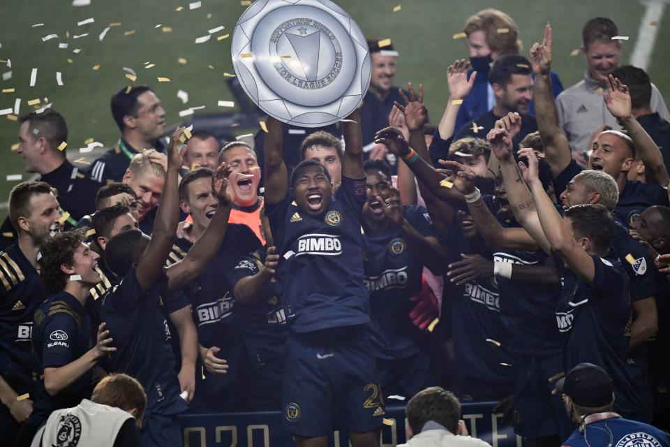 Former Philadelphia Union and current FC Cincinnati defender Ray Gaddis holds a makeshift Supporters Shield aloft. The Union organization had to fashion a temporary Shield replica as the actual Supporters Shield wasn't in Philadelphia yet when the Union clinched it on the final day of the 2020 regular season.