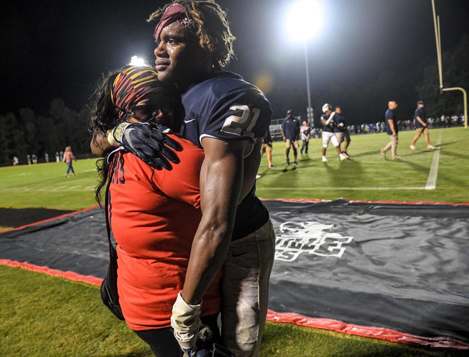 Powdersville junior Thomas Williams(21) hugs his mother Claraeisha Fruster as the team celebrates a 10-9 win over Wren in Powdersville, S.C. Friday, September 3, 2021. Powdersville High School improved to 3-0.