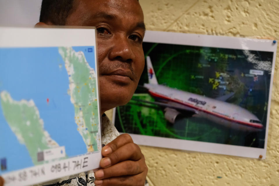 Rusli Khusmin, 42, a fisherman from Indonesia, shows a map of the location where he believes Malaysia Airlines Flight MH370 crashed into the Sumatra Indonesia Sea (Picture: Getty)