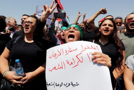 Protestors chant slogans during a demonstration near the Israeli embassy in Amman, Jordan July 28, 2017. The poster reads "Close the terrorist embassy, dignity for the people". REUTERS/Muhammad Hamed