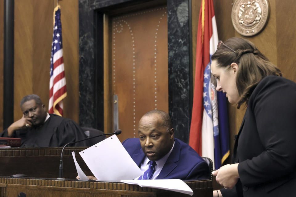 Anthony Box, center, formerly with the St. Louis Circuit Attorney's Conviction Integrity Unit, looks at evidence of payments to witness Greg Elking in 1994 as Missouri assistant attorney general Miranda Loesch, right, questions the evidence during testimony on the second day of Lamar Johnson's wrongful conviction hearing in St. Louis on Tuesday, Dec. 13, 2022. Circuit Court Judge David Mason, left, presides over the hearing.(David Carson/St. Louis Post-Dispatch via AP, Pool)