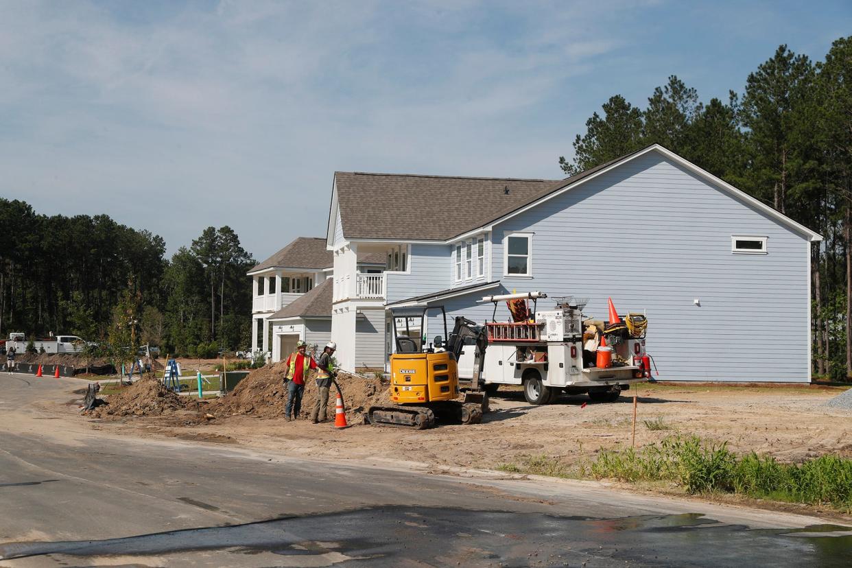 Workers run cable underground outside of new homes being built in Heartwood at Richmond Hill in 2022.