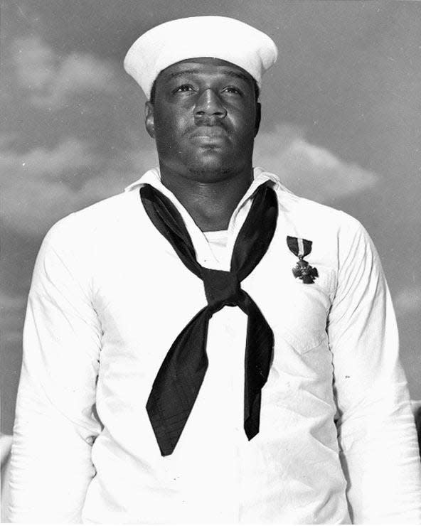 Doris "Dorie" Miller, Mess Attendant Second Class, USN (1919-1943) just after being presented with the Navy Cross by Admiral Chester W. Nimitz, on board USS Enterprise (CV-6) at Pearl Harbor, 27 May 1942. The medal was awarded for heroism on board USS West Virginia (BB-48) during the Pearl Harbor Attack, 7 December 1941.