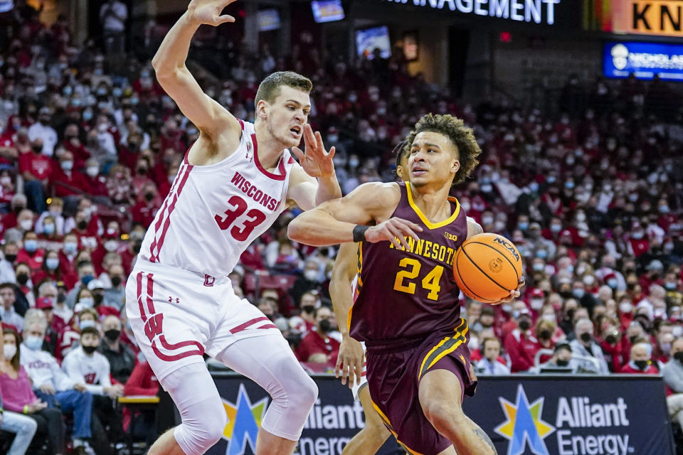 Minnesota's Sean Sutherlin (24) drives against Wisconsin's Chris Vogt (33) during the first half of an NCAA college basketball game Sunday, Jan. 30, 2022, in Madison, Wis. (AP Photo/Andy Manis)