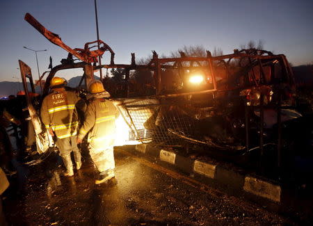 Fire-fighters inspect the wreckage of a bus was hit by a suicide bomb attack in Kabul, Afghanistan January 20, 2016. REUTERS/Omar Sobhani