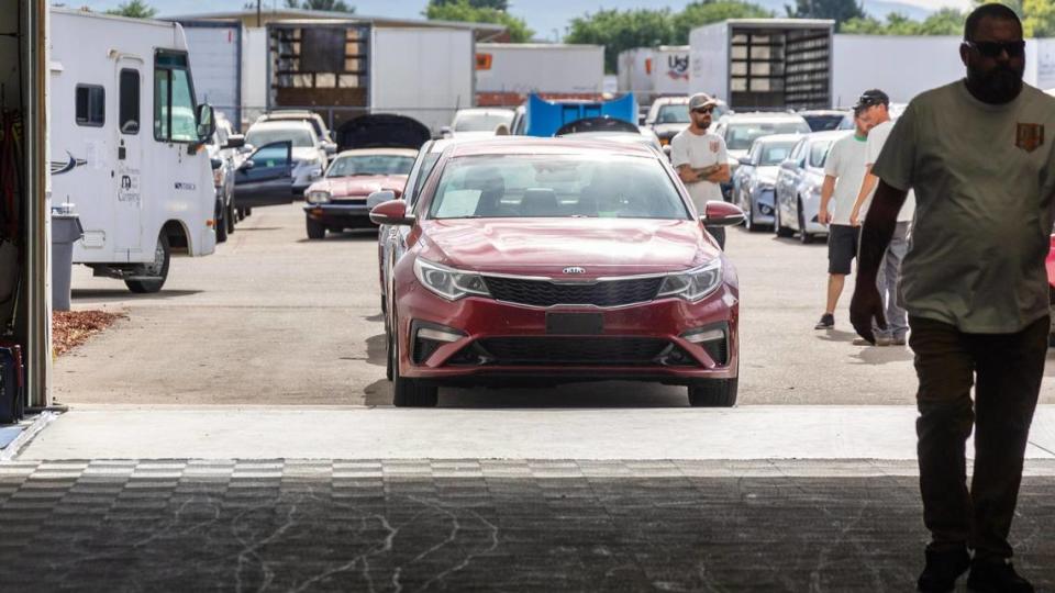 A Kia sedan is the first vehicle in line for bidding.