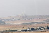 Smoke rises from the Syrian border town of Jarablus as it is pictured from the Turkish town of Karkamis, in the southeastern Gaziantep province, Turkey, August 24, 2016. REUTERS/Stringer