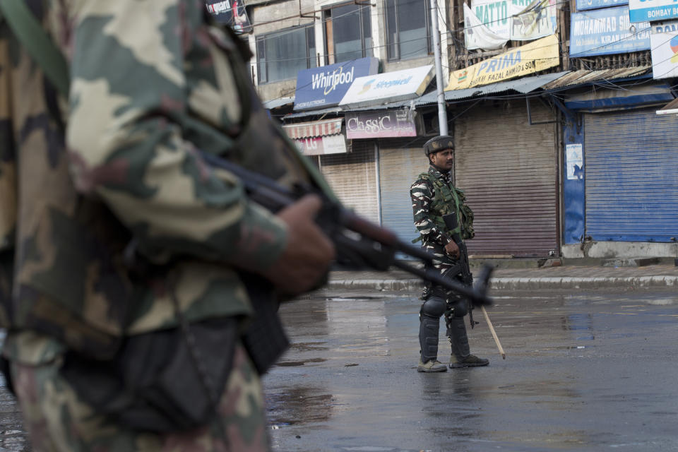 Indian Paramilitary soldiers stand guard on a deserted street during curfew in Srinagar, Indian controlled Kashmir, Thursday, Aug. 8, 2019. The lives of millions in India's only Muslim-majority region have been upended since the latest, and most serious, crackdown followed a decision by New Delhi to revoke the special status of Jammu and Kashmir and downgrade the Himalayan region from statehood to a territory. Kashmir is claimed in full by both India and Pakistan, and rebels have been fighting Indian rule in the portion it administers for decades. (AP Photo/Dar Yasin)