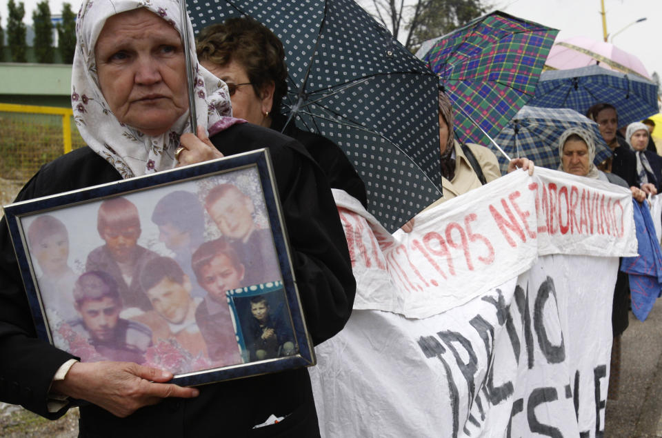 FILE - Bosnian Muslim women, and survivors of the Srebrenica massacre carry photos of relatives and display a banner with names of missing relatives, during a peaceful protest walk, in Tuzla, 72 kms north of Bosnian capital of Sarajevo, Sunday, April 12, 2010. Survivors of war crimes committed during Bosnia’s 1992-95 war say the victims of ongoing human rights abuses in Ukraine should learn from their experience of fighting for justice, but that they must first make peace with the fact that reaching it will inevitably be a lengthy and painful process. It took decades to arrest and try the wartime Bosnian Serb leaders, and three decades since the start of that war more than 7,000 people remain unaccounted-for. (AP Photo/Amel Emric, File)