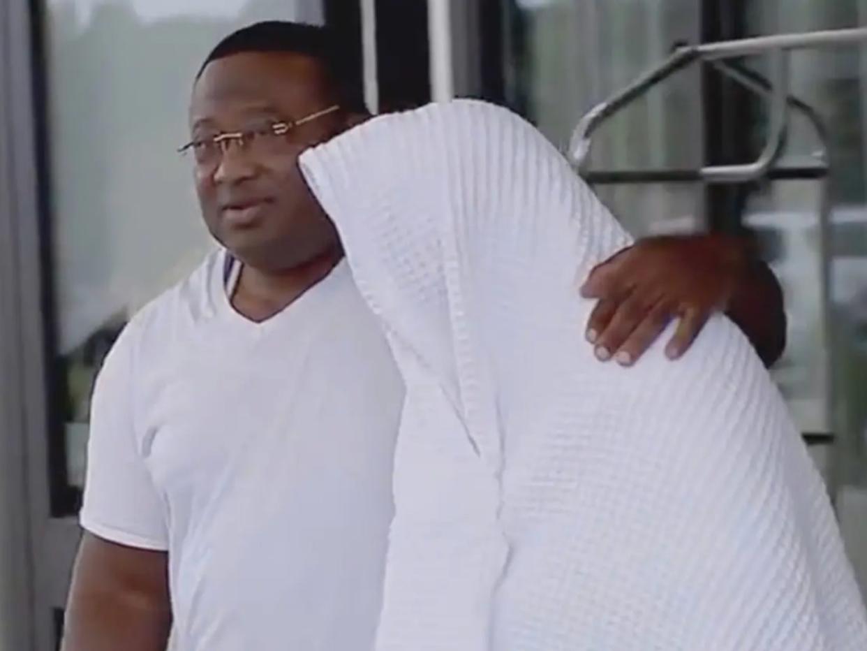 Community activist Quanell X leads Rudy Farias out of a police meeting on Wednesday (ABC13)