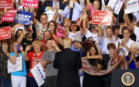 Trump looks to his VIP section during his campaign rally speech in Phoenix - Credit: EPA