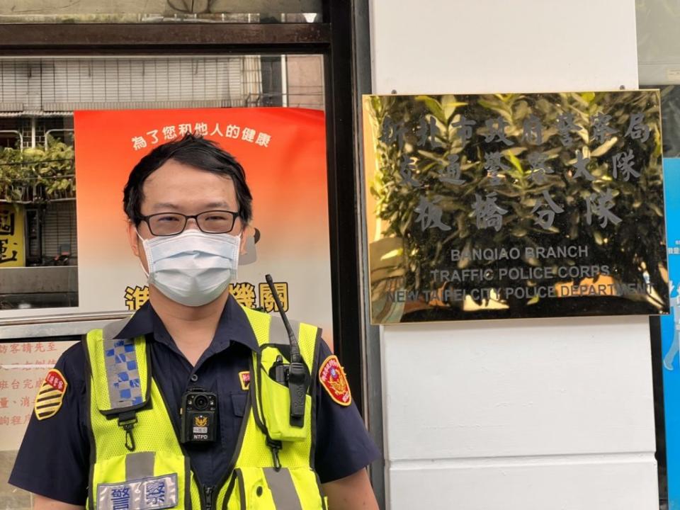 警員林鵬飛相當熱心，使用車內備用千斤頂，協助小客車駕駛更換備胎。（板橋警分局提供）