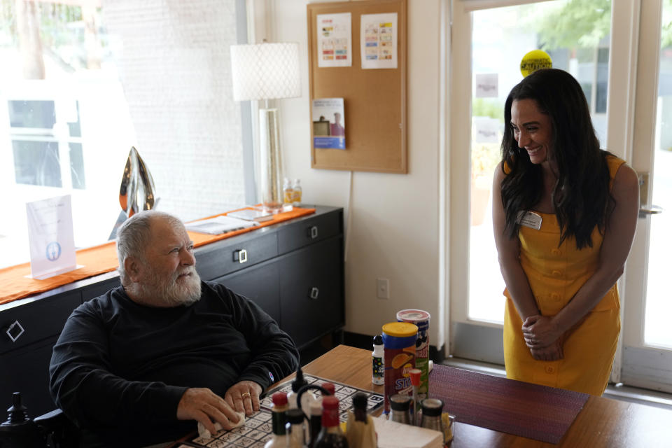 Lauren Kabakoff Vincent, right, interim executive director of Stonewall Gardens, talks with resident Billy Kurch at the LGBTQ+ assisted living facility, Tuesday, Aug. 15, 2023, in Palm Springs, Calif. The center's staff are required to go through sensitivity training to help make the center a more welcoming environment for residents, Vincent says. The training is key for making a more accepting environment for transgender residents and making them feel more at home. (AP Photo/Marcio Jose Sanchez)