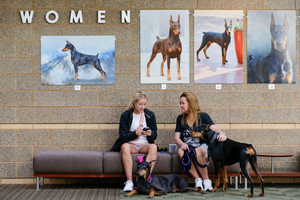 Peyton Paterson and her mom Susan Paterson from Chicago sit with their dogs Piper, 7, (left) and Reign, 3, in the lobby during the 96th annual Doberman Pinscher Club of America National Show and Convention at the Expo Center on Tuesday, Sept. 26, 2023.