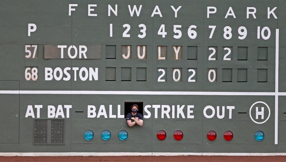 <p>The scoreboard operator watches from an opening before the exhibition game against the Toronto Blue Jays on July 22 in Boston.</p>