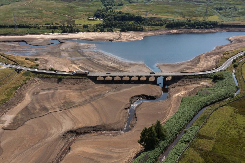 Traffic crosses a bridge at Woodhead Reservoir in West Yorkshire, England, Monday, July 18, 2022 as water levels dip dangerously low amid record high temperatures in the UK. 