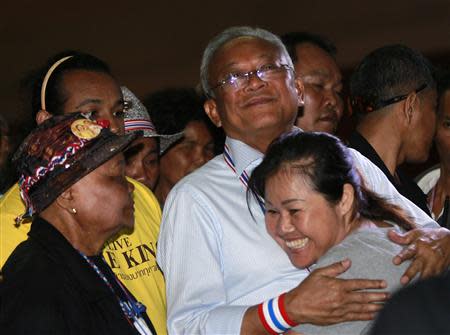 Anti-government protest leader and former deputy prime minister Suthep Thaugsuban hugs his supporter before a public seminar at Thammasat University in Bangkok December 14, 2013. REUTERS/Chaiwat Subprasom