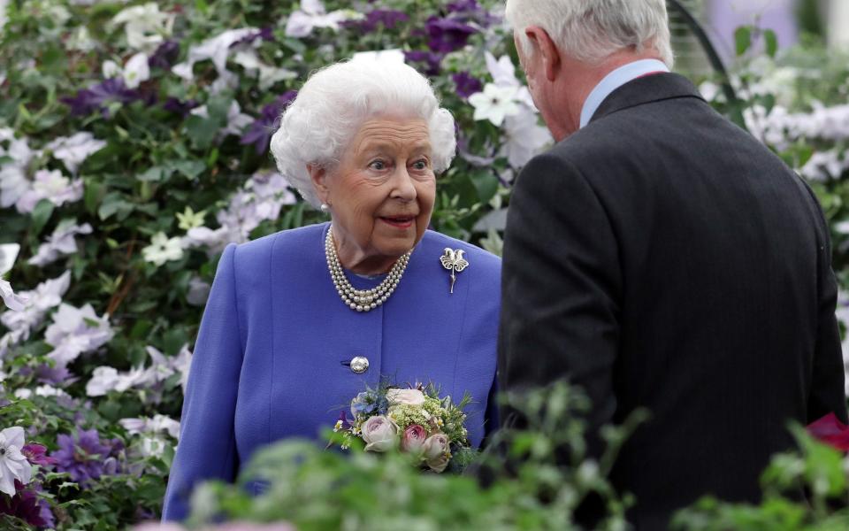 The Queen views a clematis as she visits the RHS Chelsea Flower show - © RHS