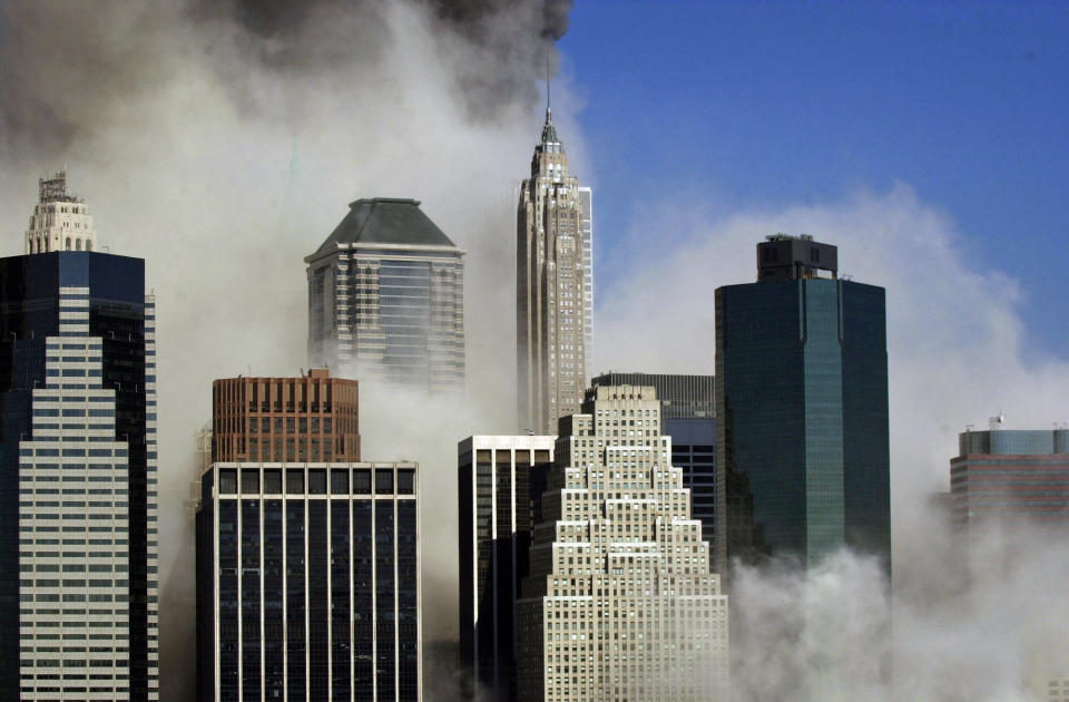 <p>Smoke billows through buildings in Manhattan as seen from Brooklyn after the collapse of New York's World Trade Center, Tuesday, Sept. 11, 2001. (AP Photo/Kathy Willens)</p> 