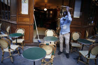 A cafe employee carries chairs as he setting up a terrace, in Paris, Tuesday, June 2, 2020. Parisians who have been cooped up for months with take-out food and coffee will be able to savor their steaks tartare in the fresh air and cobbled streets of the City of Light once more -- albeit in smaller numbers. (AP Photo/Thibault Camus)