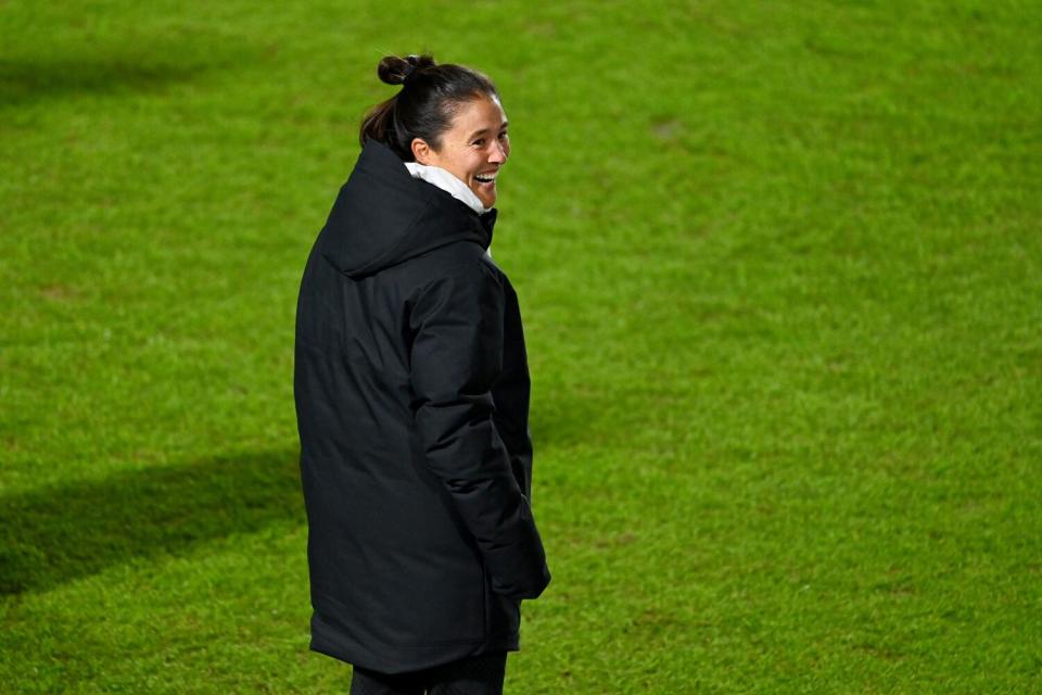 UCLA coach Margueritte Aozasa smiles from the sideline.