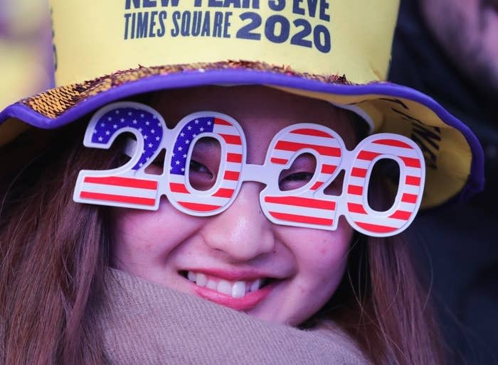 Woman wearing 2020 glasses and a New Year's Eve Times Square hat