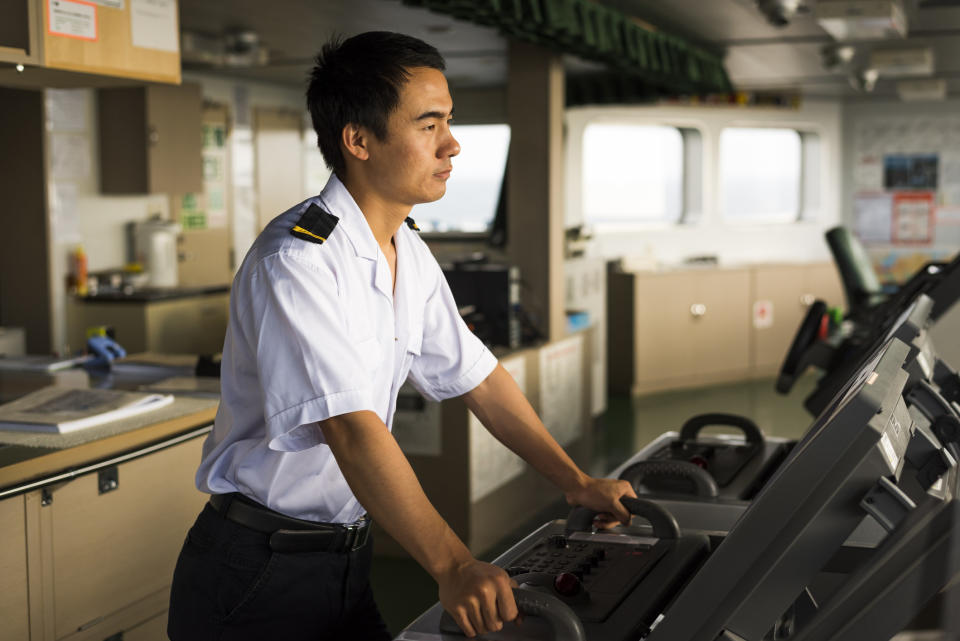 A person at the helm of a ship