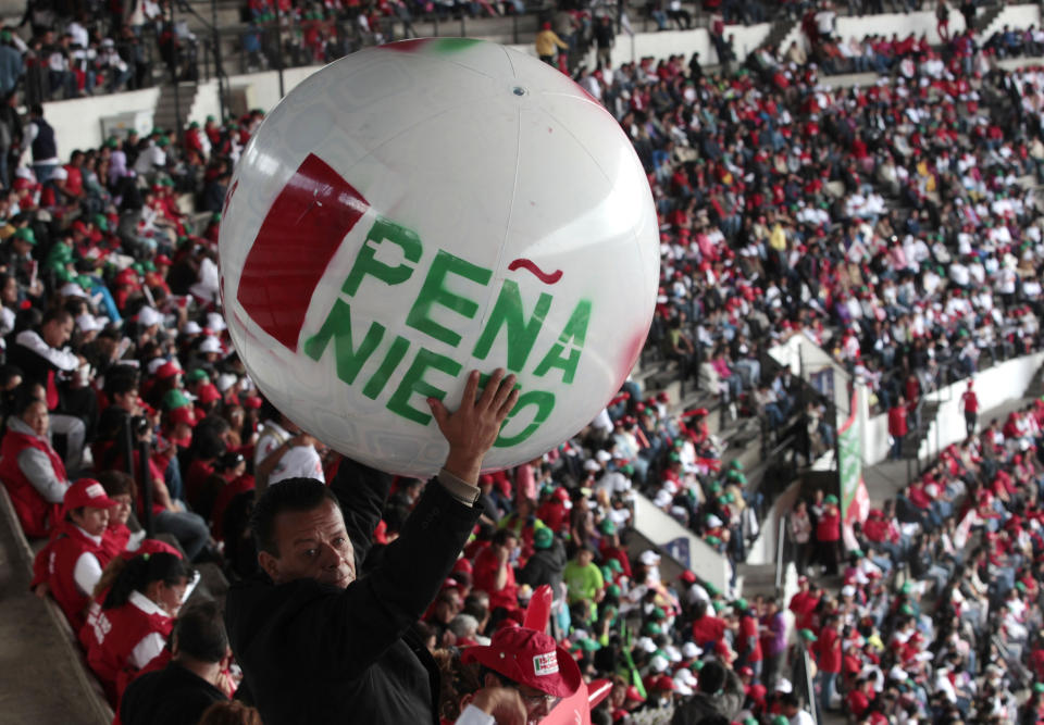 A supporter of Enrique Pena Nieto, presidential candidate of the opposition Institutional Revolutionary Party, PRI, cheers as he holds up a ball during a campaign rally at Azteca stadium in Mexico City, Sunday, June 24, 2012. General elections in Mexico are scheduled for Sunday, July 1. (AP Photo/Esteban Felix)