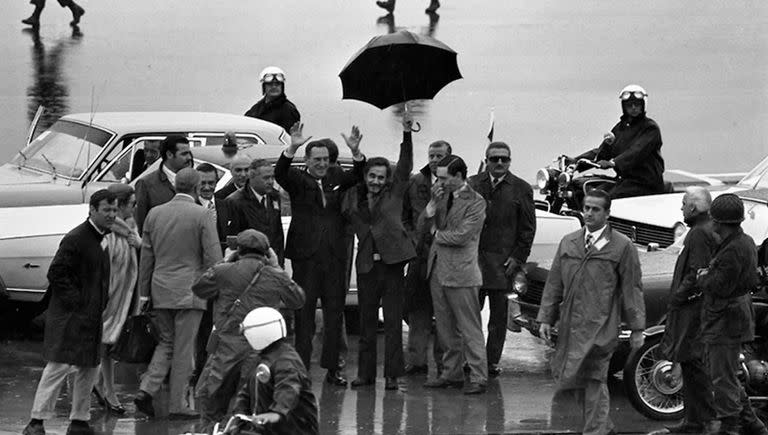 El regreso a la Argentina de Juan Domingo Perón del 17 de noviembre de 1972. Perón alza los brazos, José Ignacio Rucci levanta su paraguas y Juan Manuel Abal Medina, pensativo, se toca la cara.