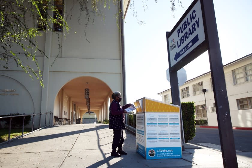 LOS ANGELES, CA - OCTOBER 29: Virginia Garibay casts their vote at the Huntington Park Library ballot drop box in Huntington Park on Thursday, Oct. 29, 2020 in Los Angeles, CA. Garibay knew to head to this location after receiving a mailer. (Dania Maxwell / Los Angeles Times)